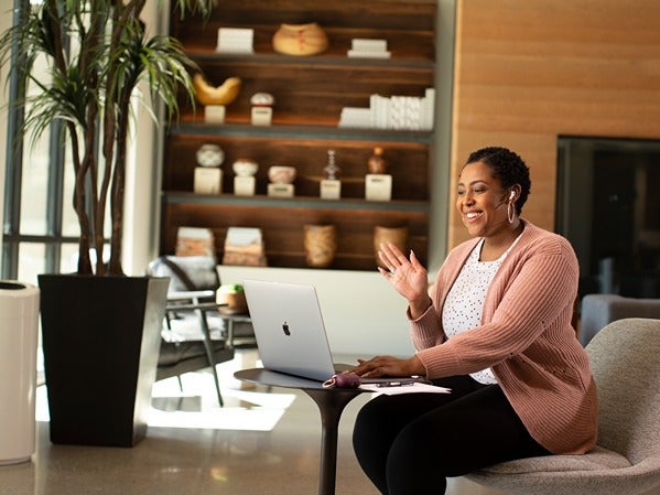 Woman on a video call in a modern, sunlit room.