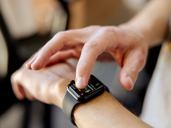 Close-up of a hand interacting with a smartwatch.