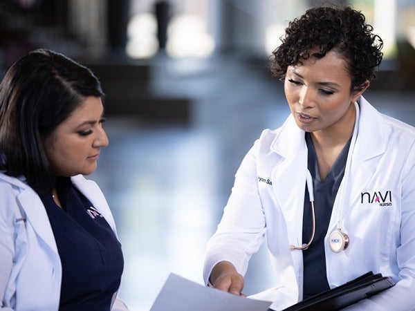 Two medical professionals discussing a document.