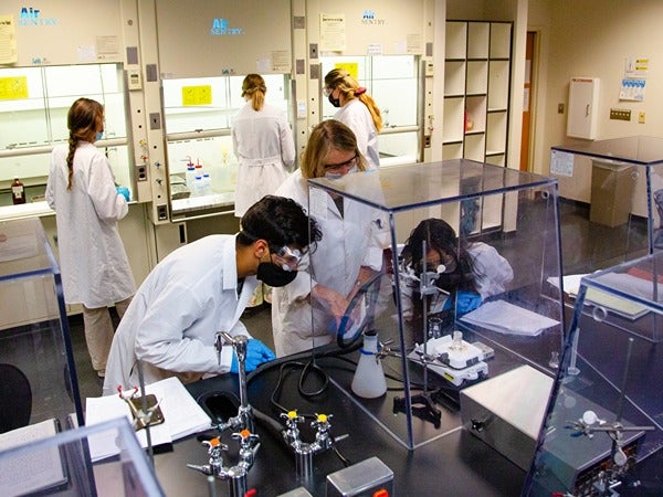 A laboratory with people in lab coats working on experiments.