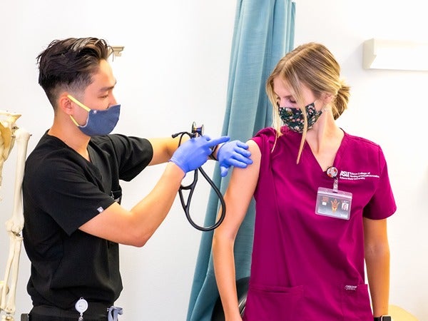 Healthcare worker giving an injection to a woman in a clinical setting.