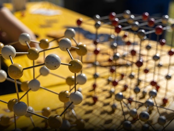 Molecular models on a yellow surface with spheres connected by rods.