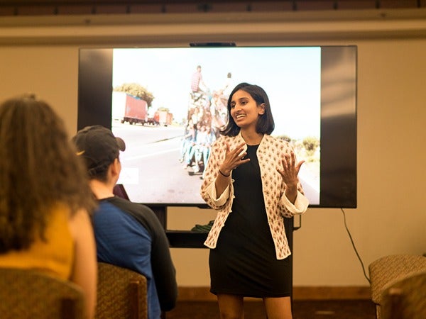 Woman giving a presentation in front of a screen.