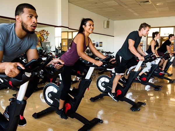 People participating in a spin class in a gym.