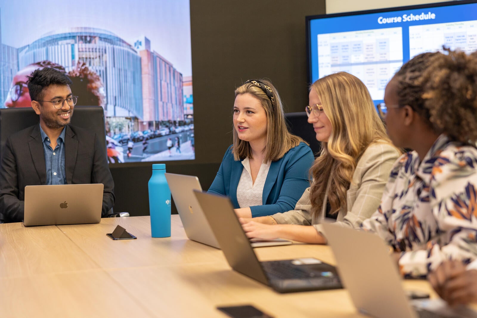 group in meeting room with laptops