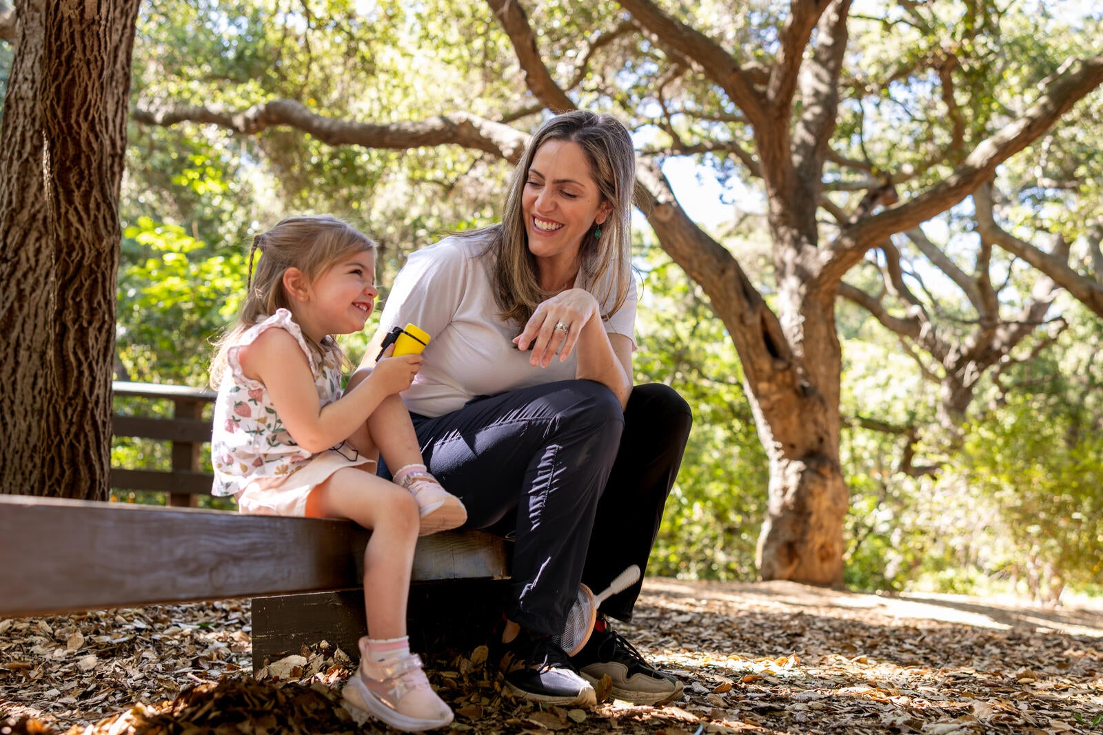 woman and child sitting outdoors on log