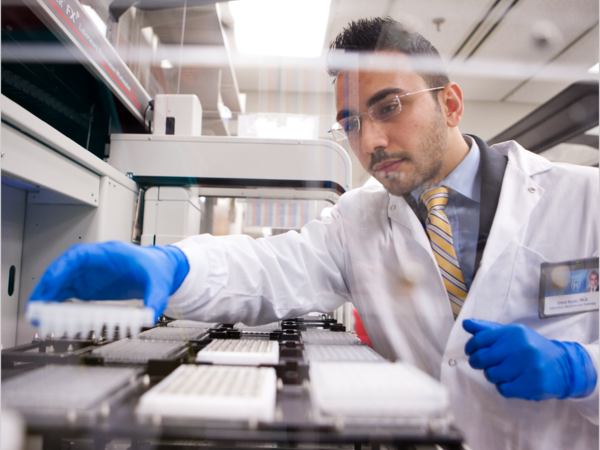 Scientist working on vials in a lab carefully