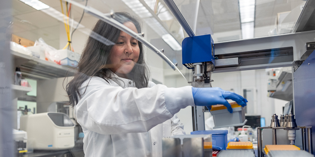 Scientist working on vials in a lab carefully